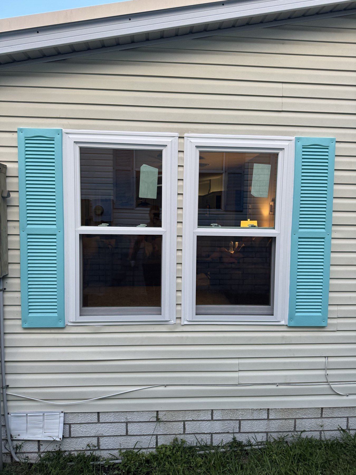 New impact windows with teal shutters — completed job